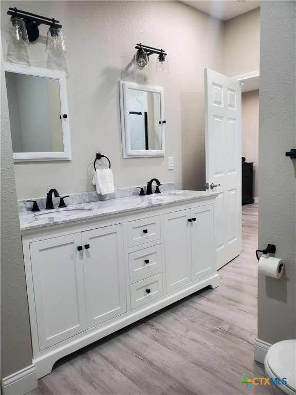 bathroom featuring hardwood / wood-style floors, vanity, and toilet