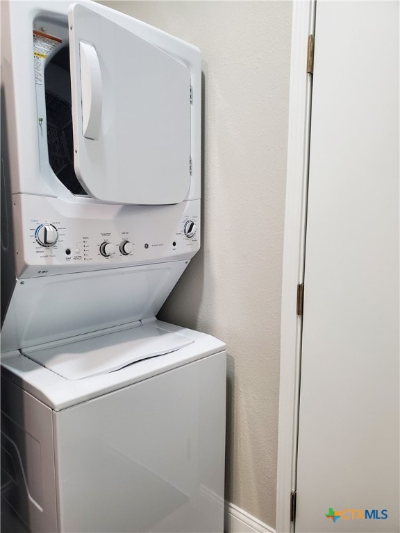 clothes washing area with stacked washer and clothes dryer