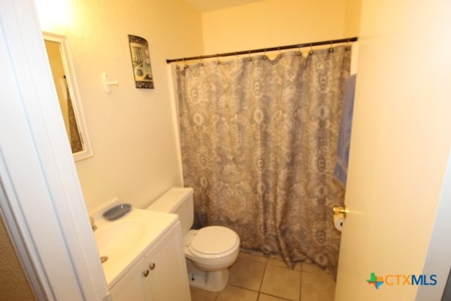 bathroom featuring toilet, vanity, tile patterned flooring, and walk in shower