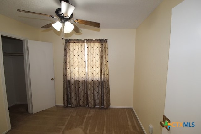 unfurnished bedroom featuring a closet, a spacious closet, and ceiling fan