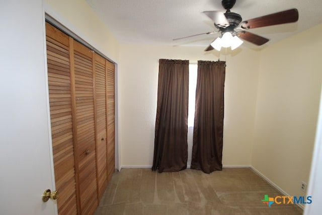 unfurnished bedroom with carpet, ceiling fan, and a closet