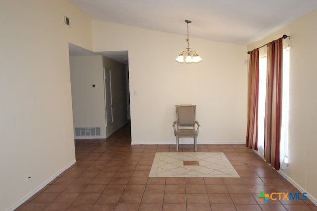 tiled empty room with an inviting chandelier and vaulted ceiling