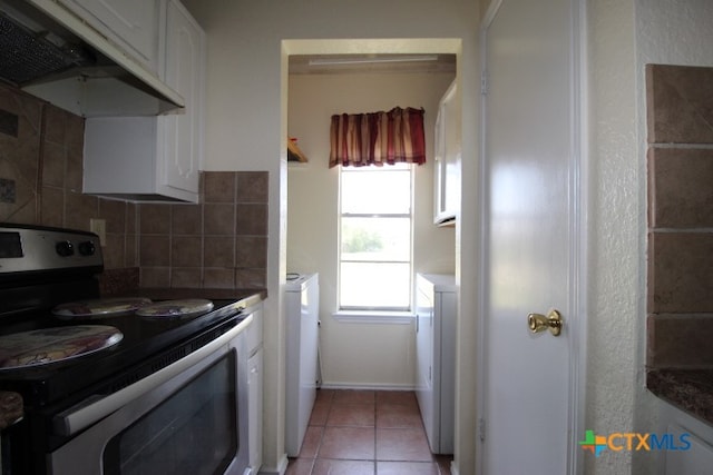 kitchen featuring white cabinetry, decorative backsplash, light tile patterned flooring, and white range with electric stovetop