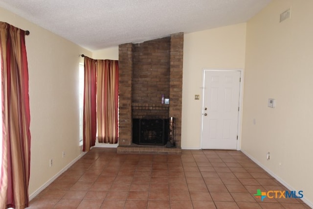 unfurnished living room featuring a brick fireplace, tile patterned flooring, a textured ceiling, and lofted ceiling