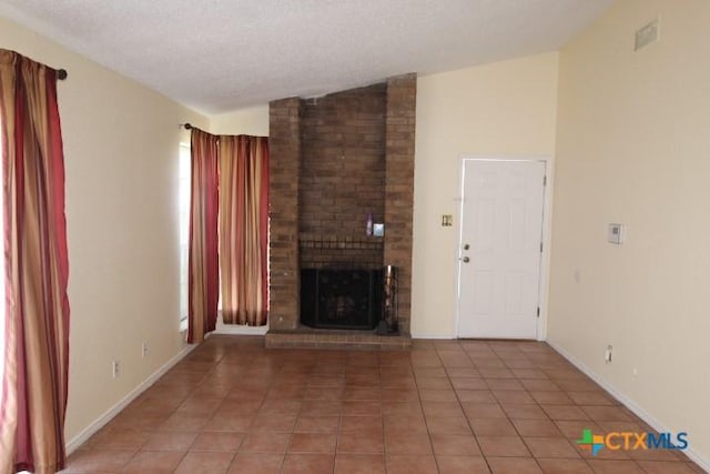 2305 Chestnut Dr, Killeen, TX 76543 - unfurnished living room with light tile patterned floors, a brick fireplace, vaulted ceiling, a textured ceiling, and baseboards