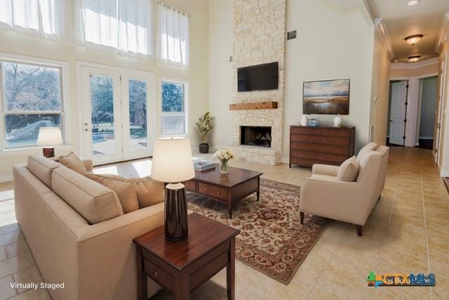 tiled living room featuring a stone fireplace and a high ceiling