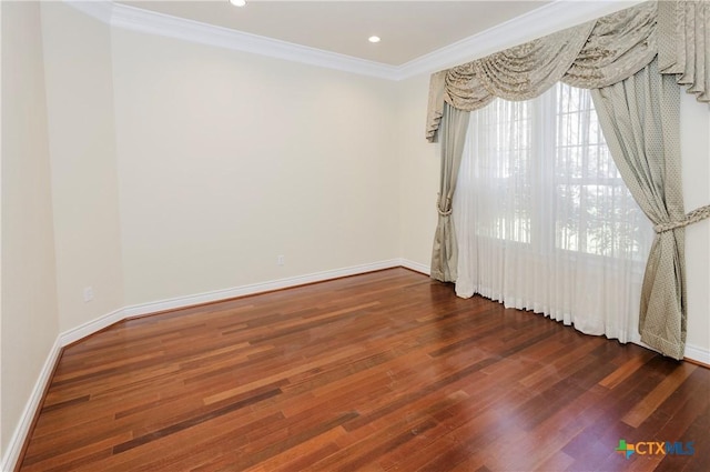 spare room with ornamental molding and dark hardwood / wood-style floors