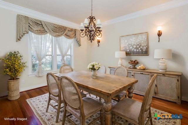 dining space with hardwood / wood-style floors, ornamental molding, and a chandelier