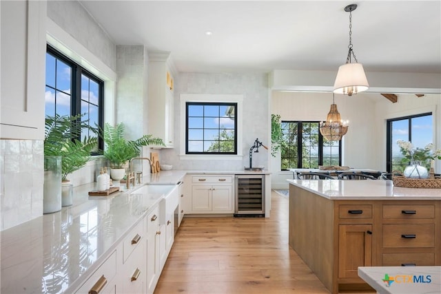 kitchen featuring a wealth of natural light, light wood finished floors, and wine cooler