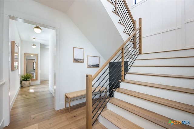 stairway with baseboards and wood finished floors