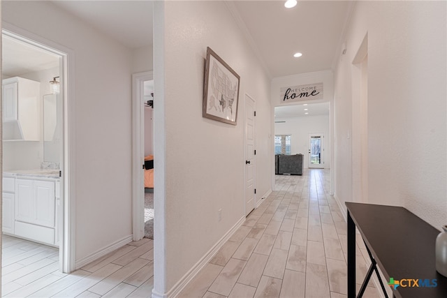 corridor with light hardwood / wood-style flooring and crown molding