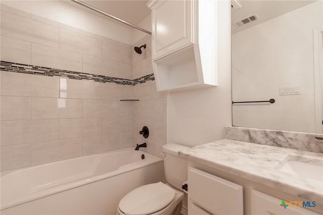 full bathroom with vanity, tiled shower / bath combo, and toilet