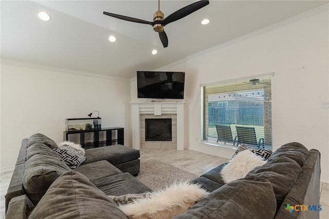 living room featuring a tiled fireplace, ceiling fan, crown molding, and light wood-type flooring