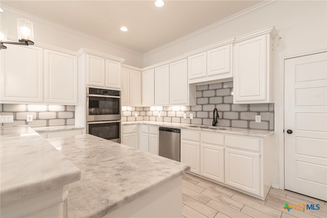 kitchen with white cabinetry, stainless steel appliances, sink, and pendant lighting