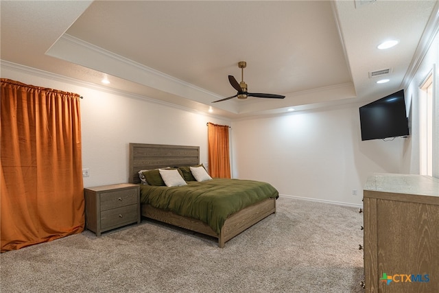 carpeted bedroom featuring ceiling fan, crown molding, and a raised ceiling