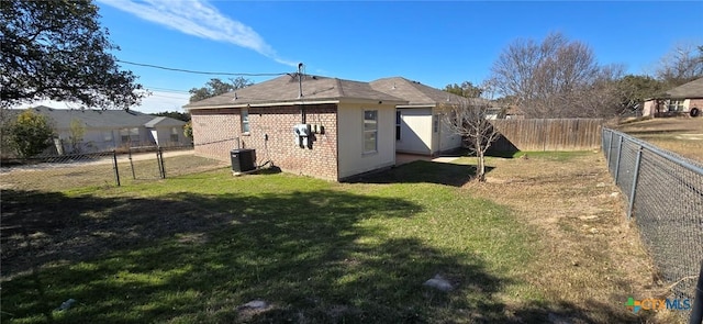 rear view of house with a yard and central AC unit