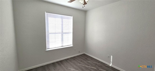 spare room featuring dark hardwood / wood-style flooring and ceiling fan