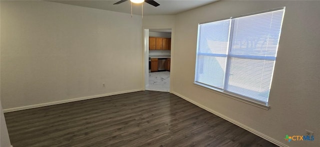 spare room featuring dark wood-type flooring and ceiling fan