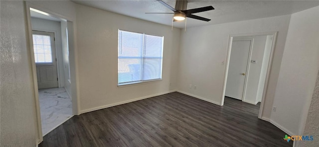 spare room with dark hardwood / wood-style flooring and ceiling fan