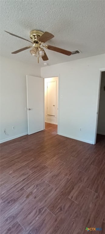 unfurnished room with ceiling fan, dark wood-type flooring, and a textured ceiling