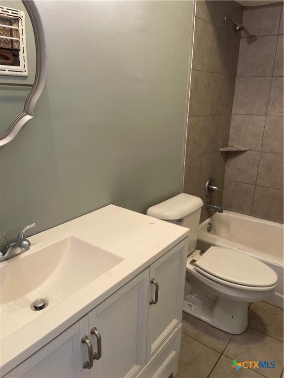 704 E 2nd St, Victoria, TX 77901 - full bath with vanity, tile patterned floors, and  shower combination