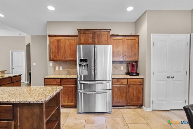 203 Terravista Trl, Victoria, TX 77904 - kitchen with stainless steel refrigerator with ice dispenser, backsplash, brown cabinetry, and recessed lighting