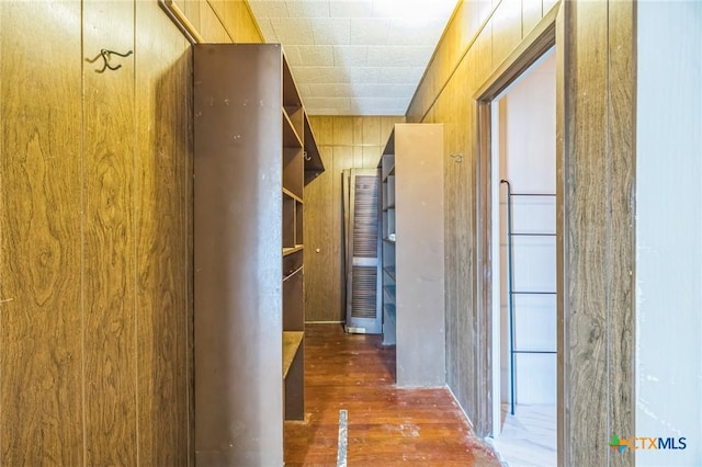 hallway with wooden walls and wood finished floors