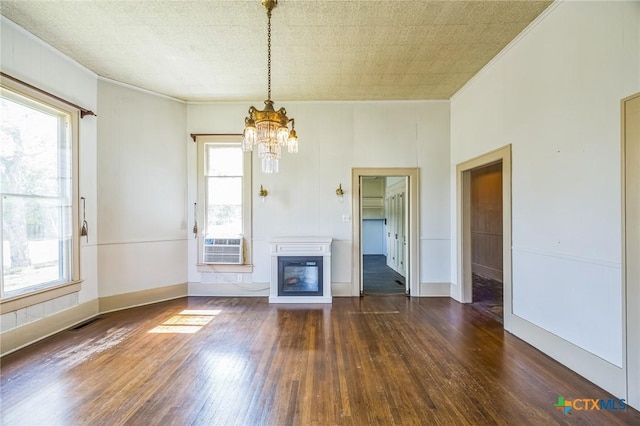 unfurnished living room with ornamental molding, hardwood / wood-style flooring, visible vents, and a chandelier