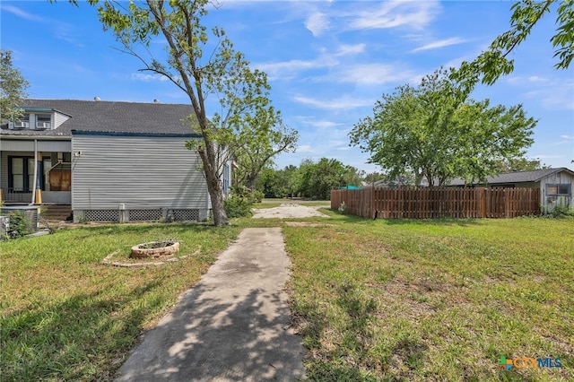 view of yard with an outdoor fire pit and fence
