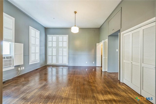 unfurnished dining area with wood-type flooring and baseboards