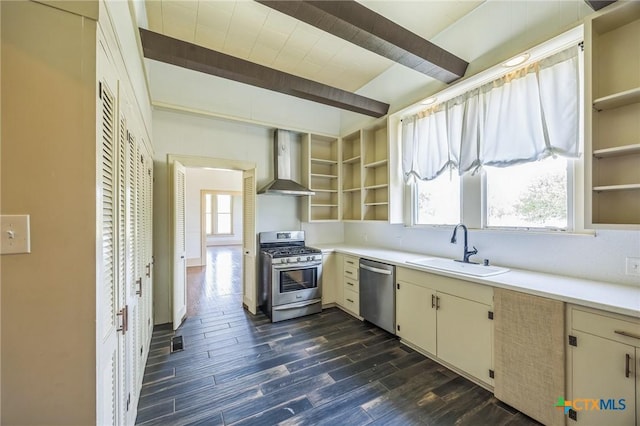kitchen with wall chimney range hood, appliances with stainless steel finishes, open shelves, and a sink