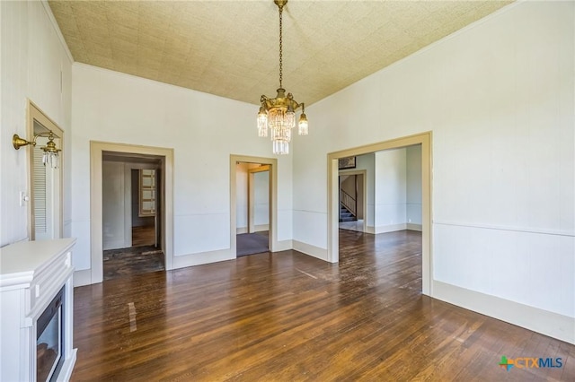 unfurnished dining area with stairway, crown molding, dark wood finished floors, and a chandelier