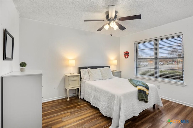 bedroom with ceiling fan, a textured ceiling, baseboards, and wood finished floors