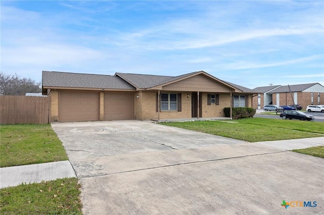 single story home featuring brick siding, concrete driveway, an attached garage, fence, and a front lawn