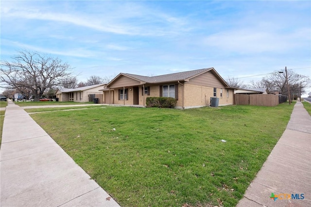 view of front of property featuring fence, a front lawn, cooling unit, and brick siding