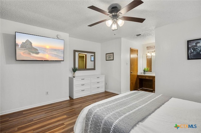 bedroom featuring dark wood-style flooring, a ceiling fan, connected bathroom, a textured ceiling, and baseboards