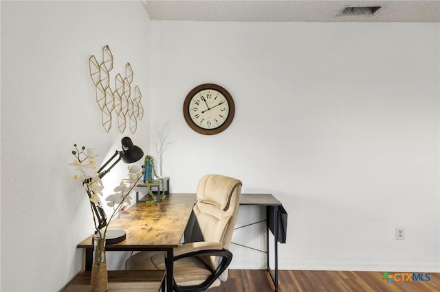 office area with baseboards, visible vents, and dark wood finished floors