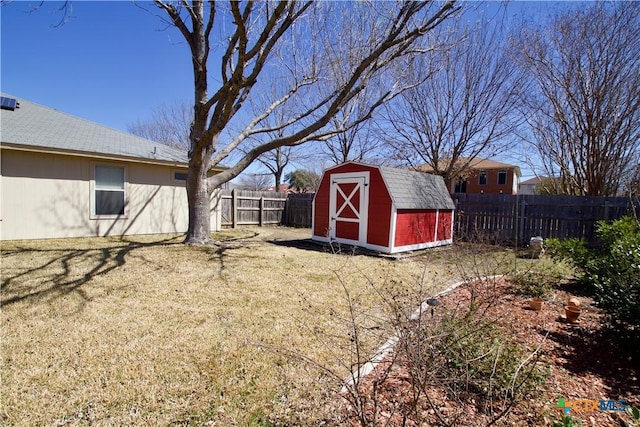 view of yard featuring a storage shed, an outbuilding, and a fenced backyard