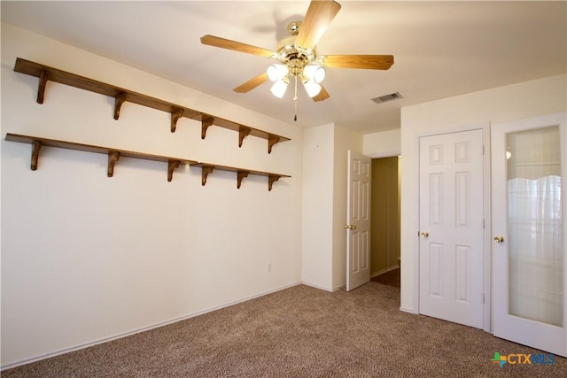 unfurnished bedroom with visible vents, ceiling fan, and carpet