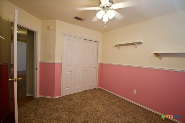 unfurnished bedroom featuring a closet, visible vents, carpet flooring, and a ceiling fan