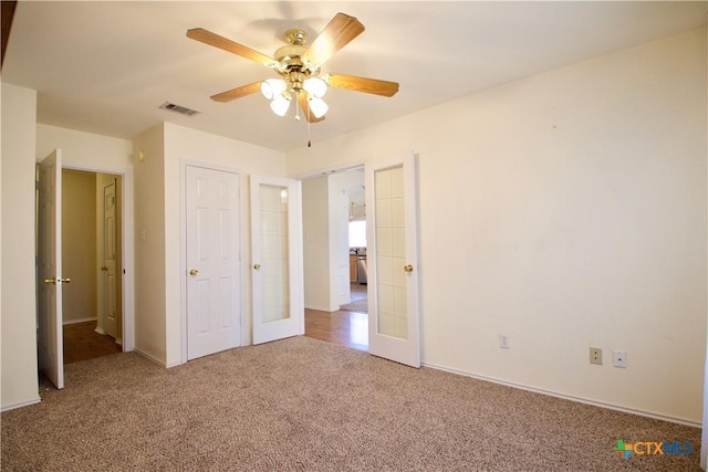 unfurnished bedroom featuring visible vents, french doors, a ceiling fan, and carpet floors