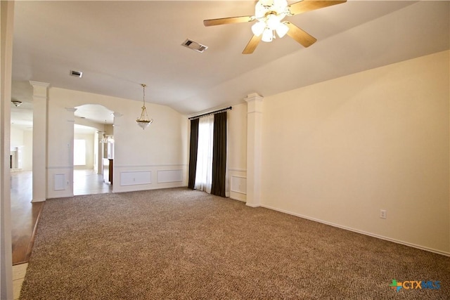 unfurnished room featuring arched walkways, visible vents, carpet flooring, and decorative columns