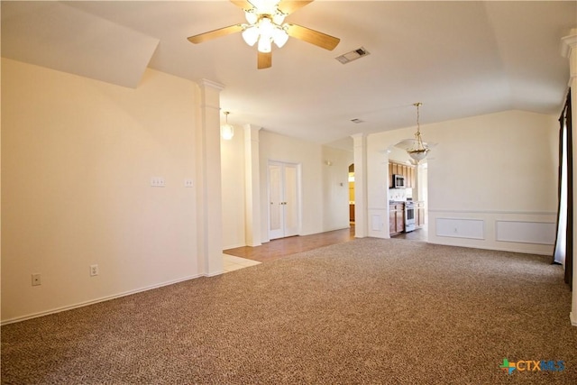 unfurnished living room featuring carpet, visible vents, decorative columns, ceiling fan, and vaulted ceiling