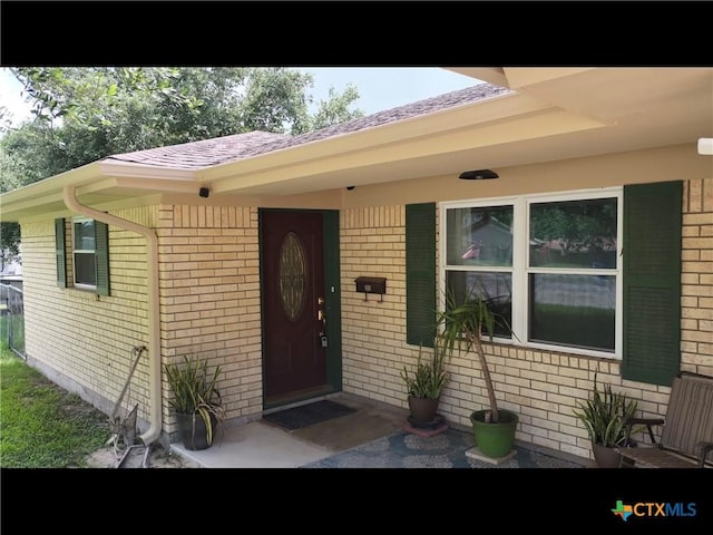 105 Brentwood Pl, Port Lavaca, TX 77979 - property entrance featuring brick siding and roof with shingles