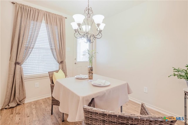 dining area with a notable chandelier and light hardwood / wood-style flooring