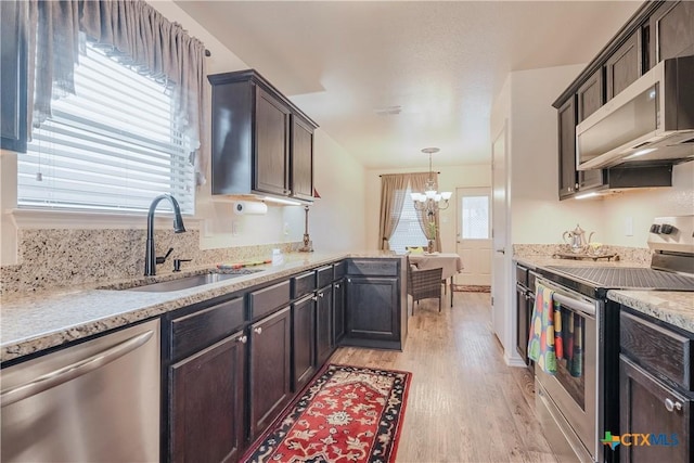 kitchen with appliances with stainless steel finishes, decorative light fixtures, sink, a chandelier, and dark brown cabinetry