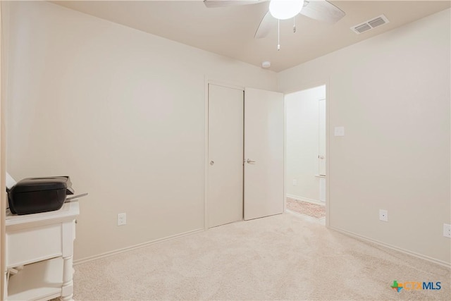 unfurnished bedroom featuring ceiling fan and light carpet