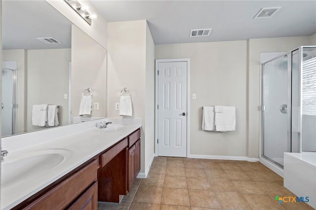 bathroom with a stall shower, visible vents, and a sink