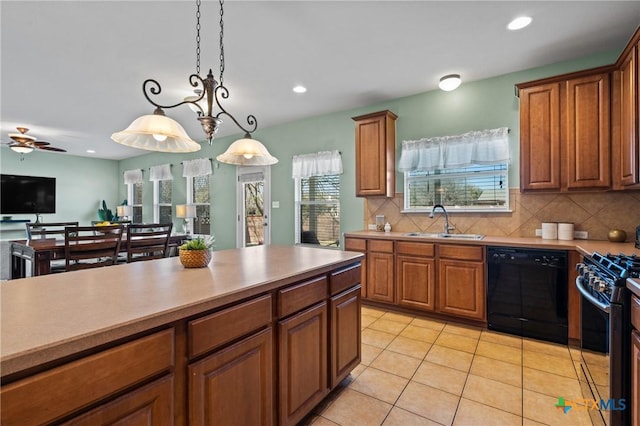 kitchen with gas range, black dishwasher, light tile patterned floors, brown cabinetry, and a sink