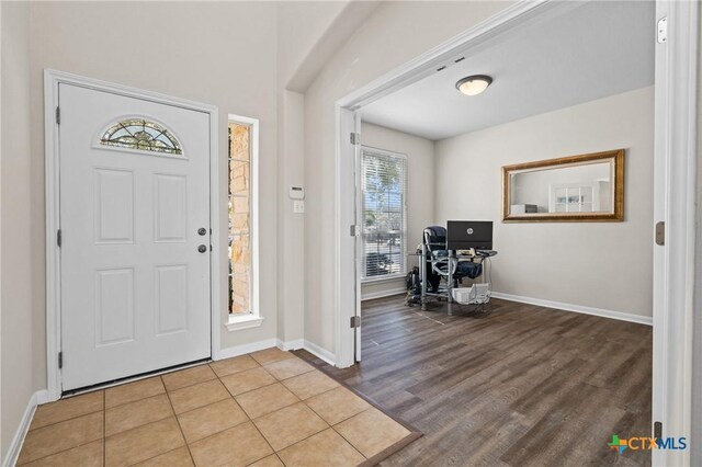 foyer entrance with wood finished floors and baseboards